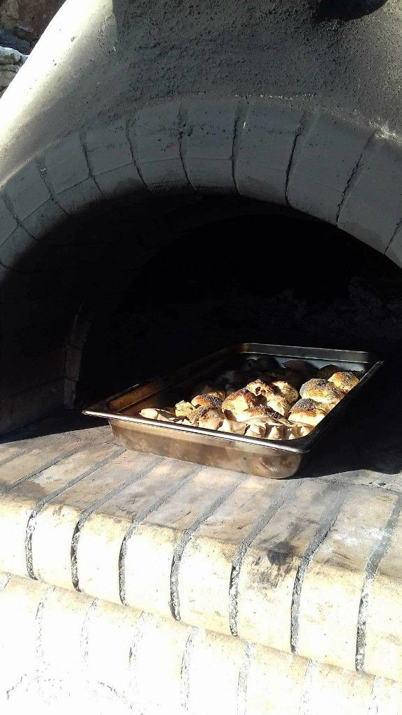 baking pan with small buns in the stone oven of 'Manalis Winery' restaurant